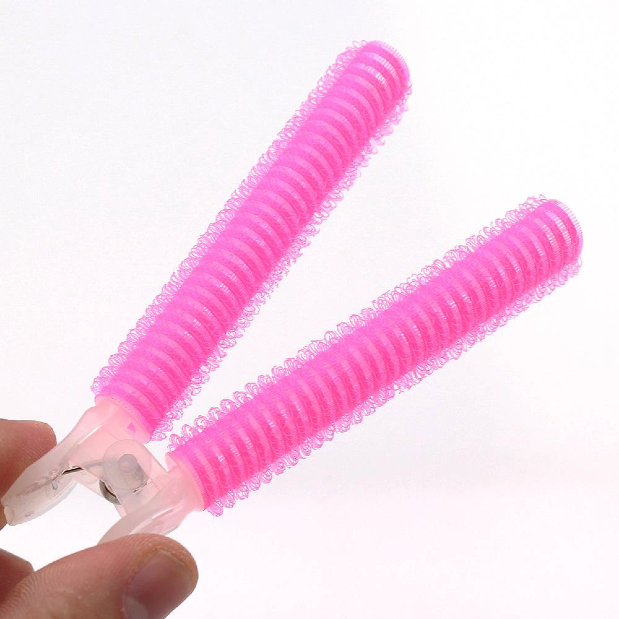 Pink hair rollers held by a hand on a white background