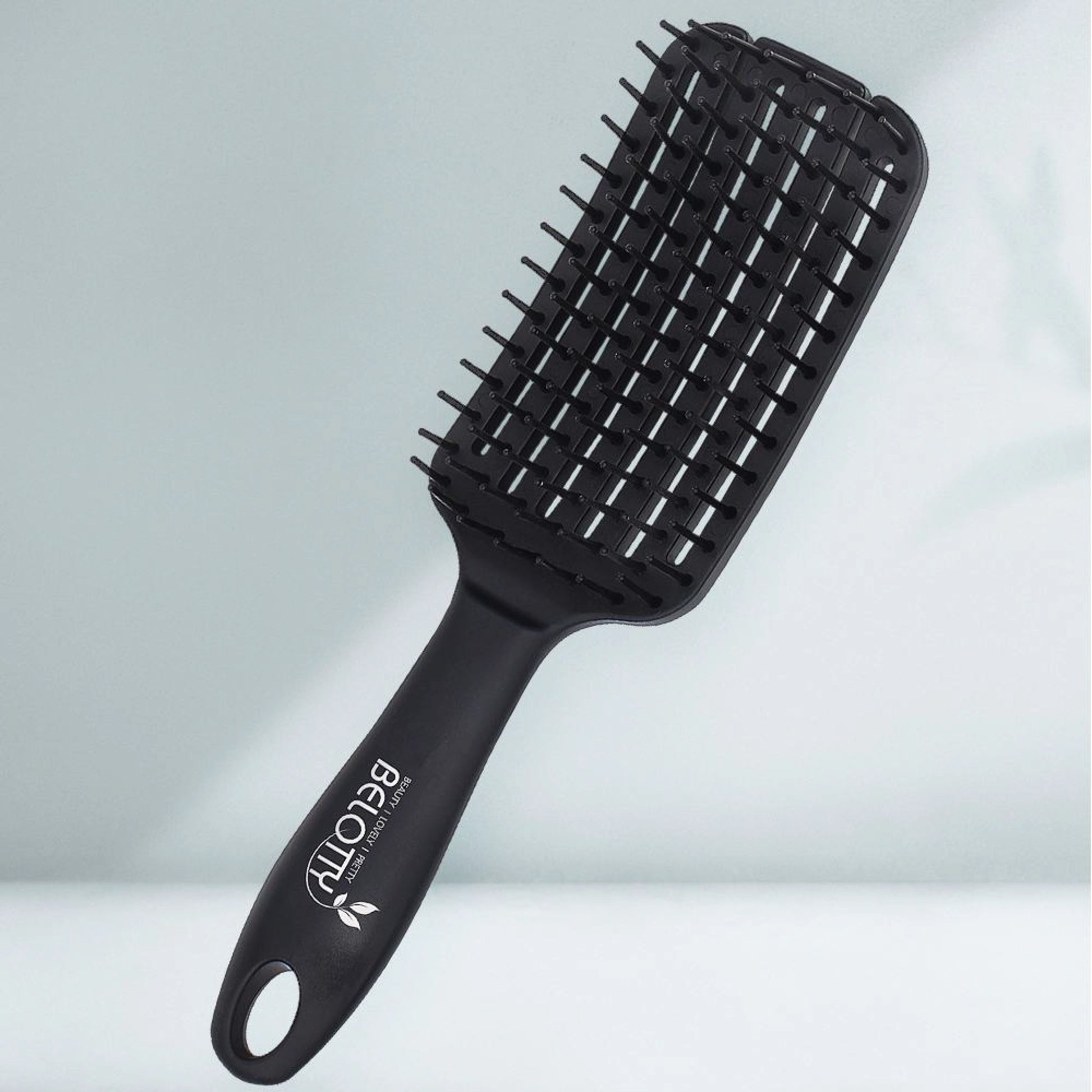 Black hairbrush with 'Belotty' branding on a light gray background